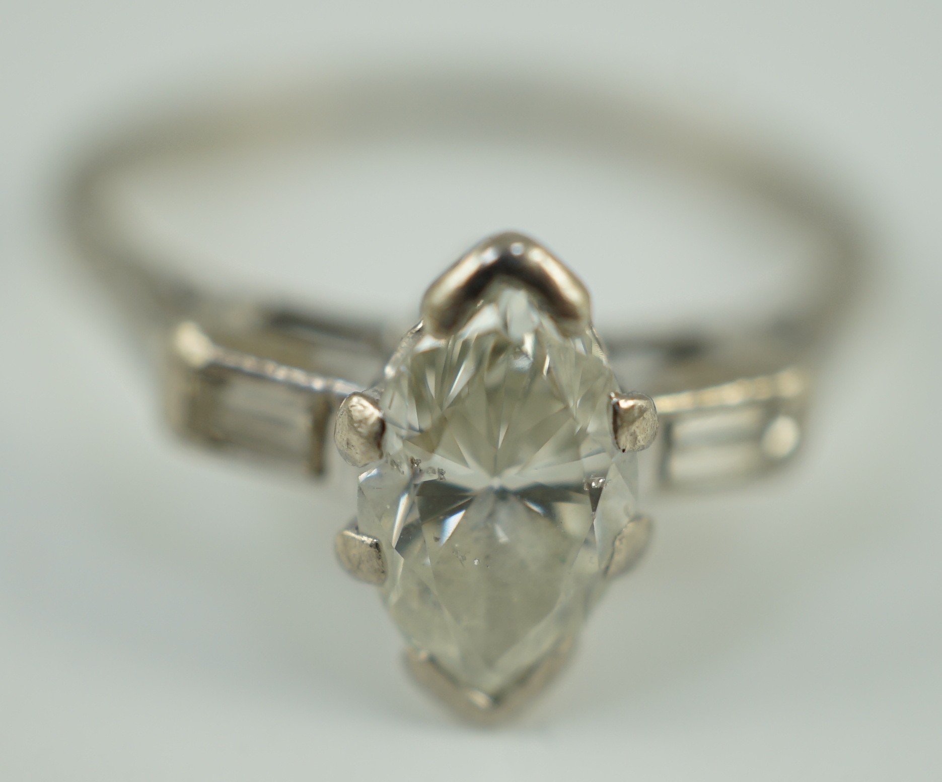 An 18ct white gold and single stone marquise cut diamond set ring, with baguette cut diamond set shoulders